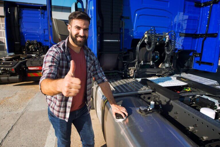 A bearded man standing beside the truck