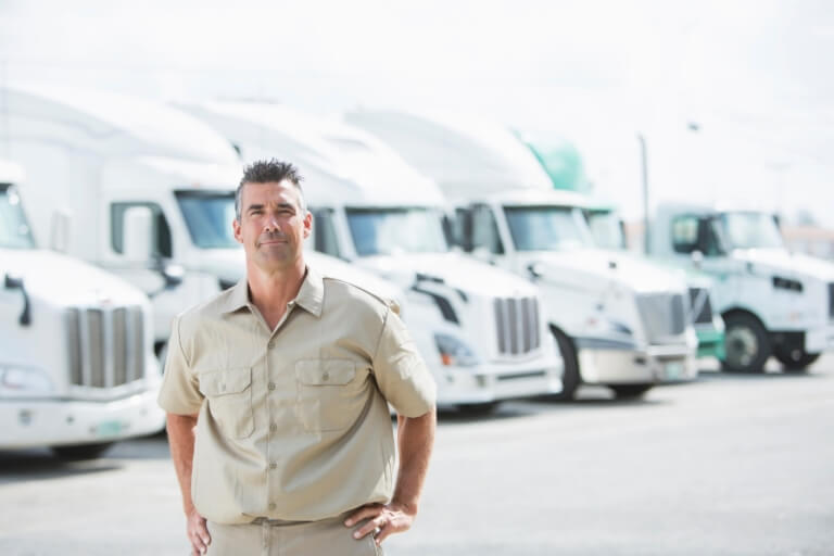 man standing afront of white trucks