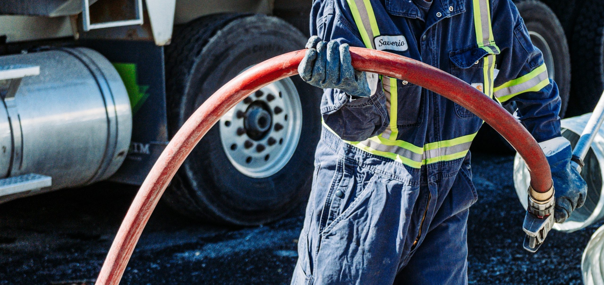 on site delivery fuel truck and employee fueling machinery at a construction site